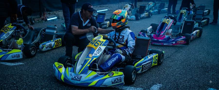 Coach LKM Racing accompagnant un jeune pilote avant une course